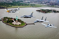 Jets flying over statue